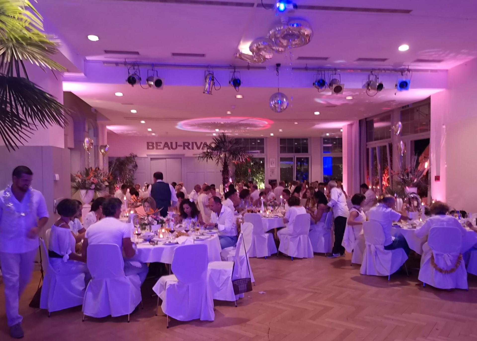 Elegante Hochzeitsgesellschaft in weiss-goldenem Ambiente mit stimmungsvoller Beleuchtung
